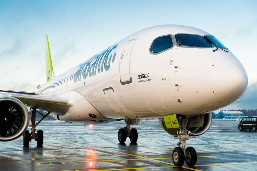An airBaltic Airbus A220 parked on the tarmac.