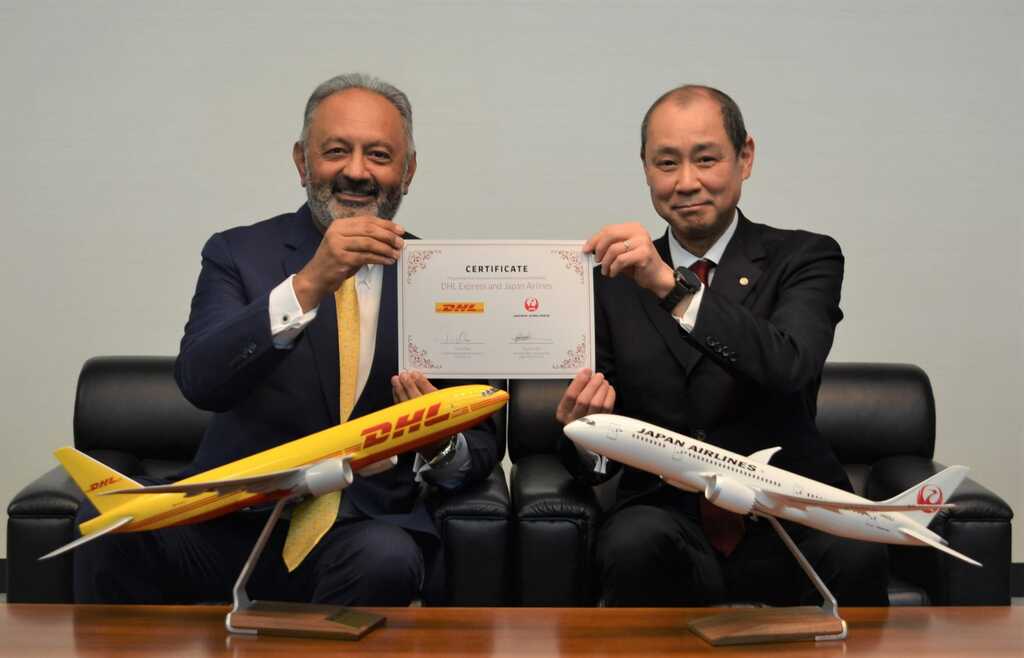 JAL and DHL officials with agreement document.