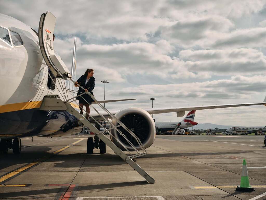 A Ryanair cabin crew member exits and aircraft.