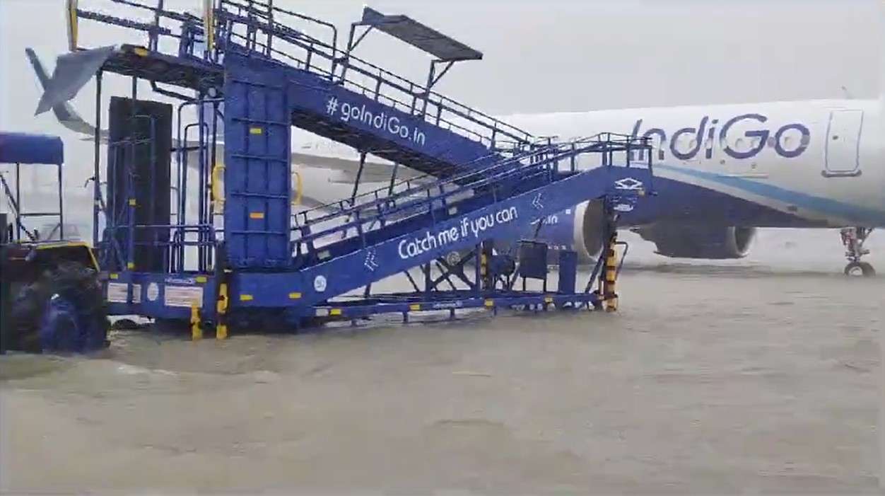 Chennai Airport flooding - heavy rain surrounds an aircraft on the tarmac.