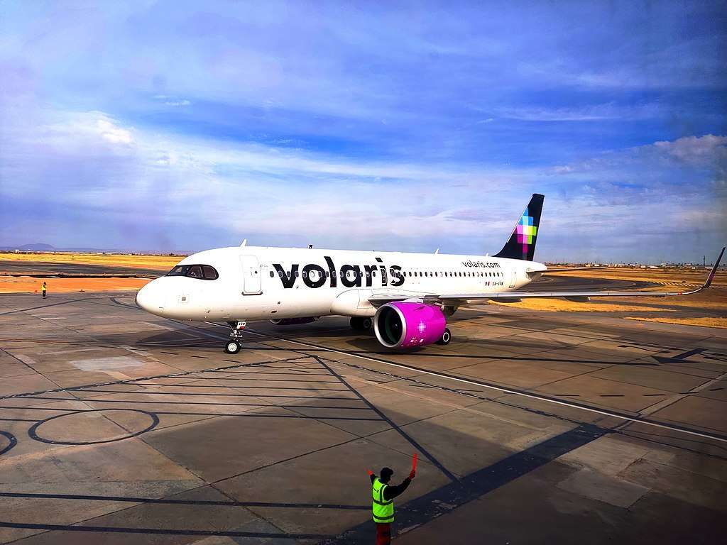 A Volaris Airbus A320 is marshalling to a parking spot.