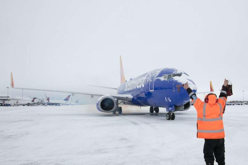 A Southwest Airlines aircraft is marshalled during snowstorm.