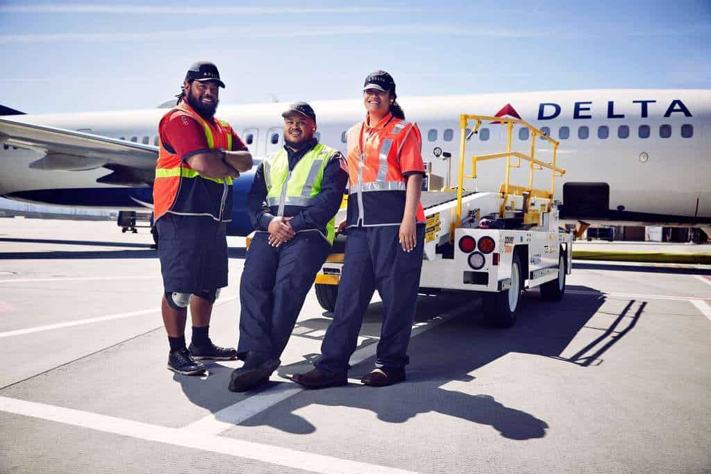 Delta Air lines ground handling staff on tarmac with aircraft.
