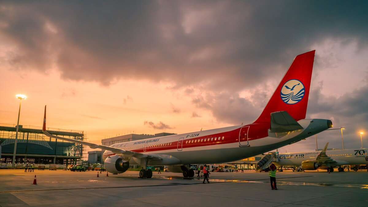 Aircraft parked at Velana International Airport at sunset.