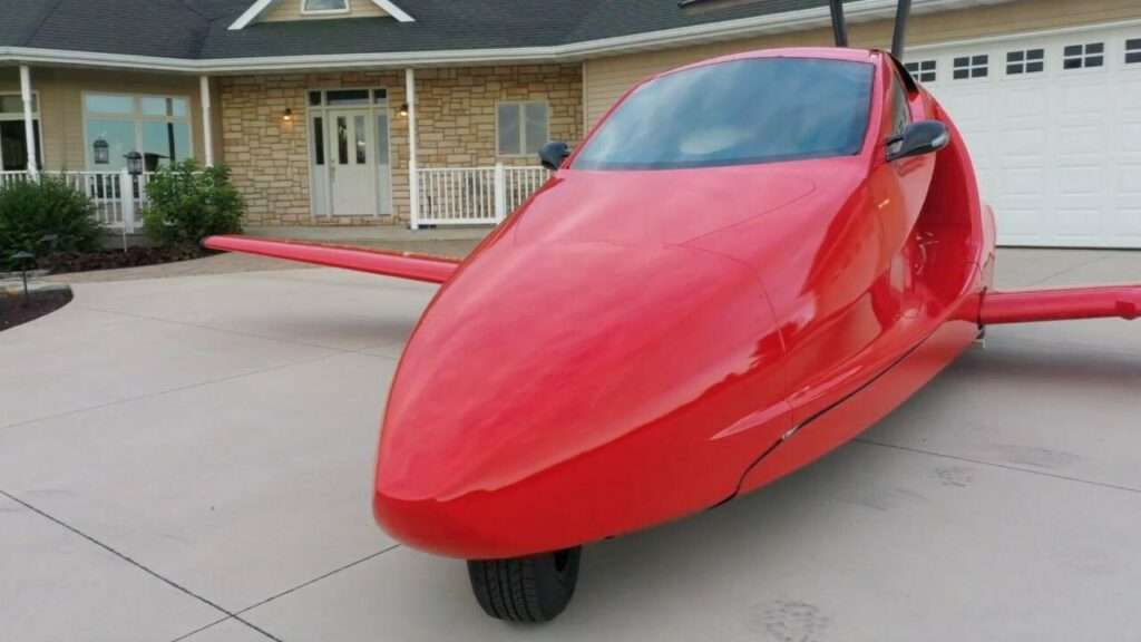 A Switchblade flying car parked in a driveway.