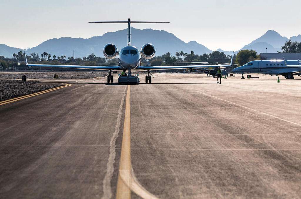 A light jet is towed on the runway.
