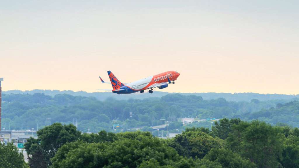A Sun Country Airlines jet climbs after takeoff.