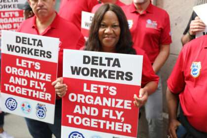 Delta Air Lines workers hold up protest signs.