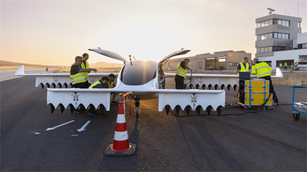 A Lilium eVTOL jet is worked on by engineers on the tarmac.