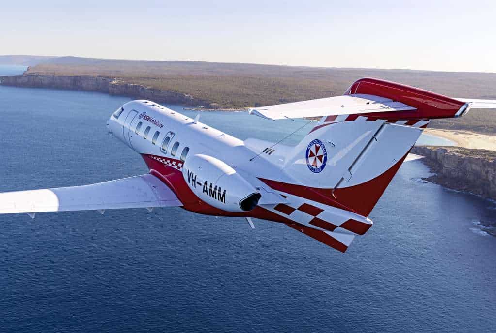 New South Wales Ambulance PC-24 in flight over coast.