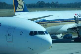 Air New Zealand and Singapore Airlines aircraft parked together.