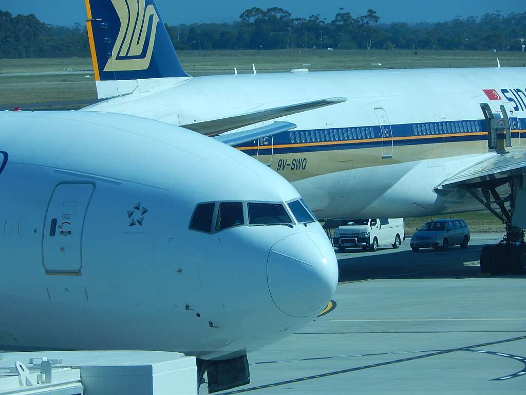Air New Zealand and Singapore Airlines aircraft parked together.