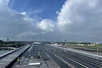 Workers install solar panels at Singapore Changi Airport