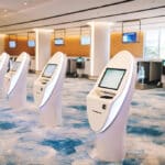 A line of automated check-in machines at an airport.