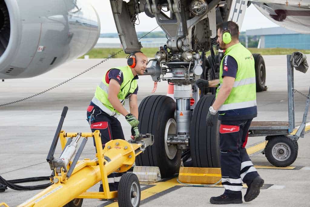 Swissport ground handlers hook up an aircraft for towing.