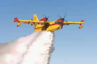 A DHC-515 firefighting aircraft drops a water load.