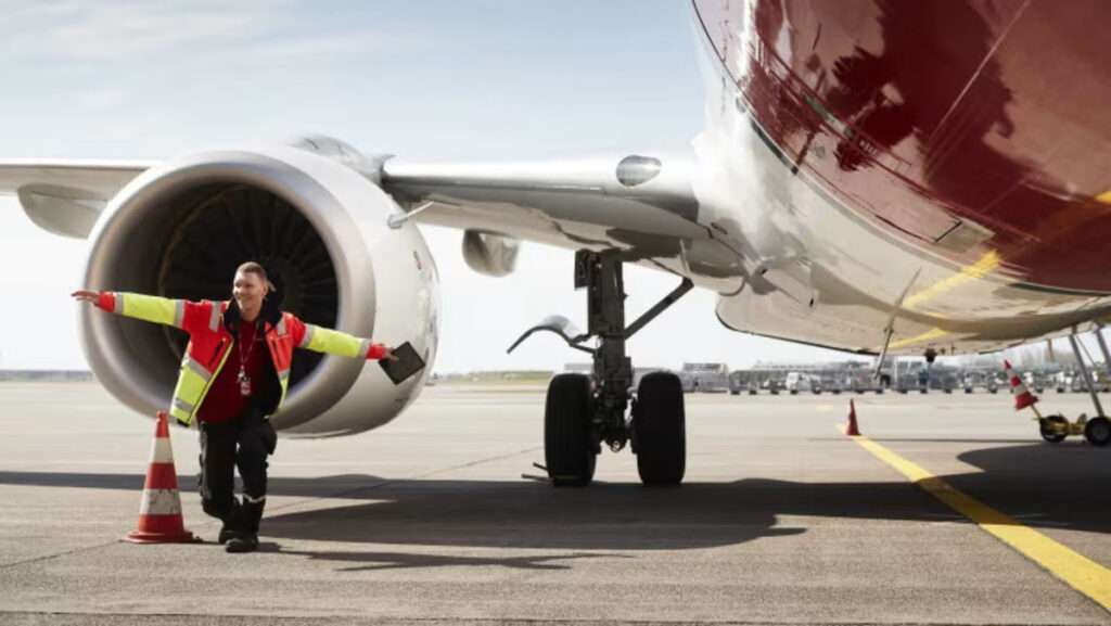 A ground staff member with a Norwegian jet.