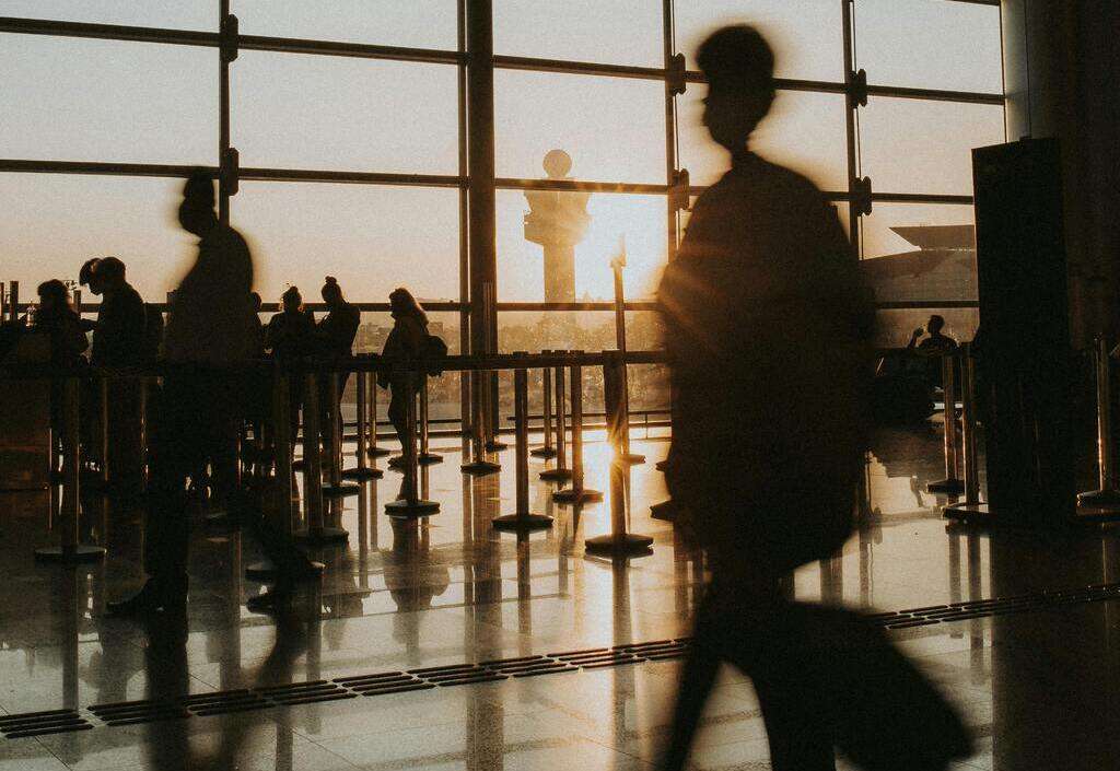 Passengers in an airport terminal at dusk
