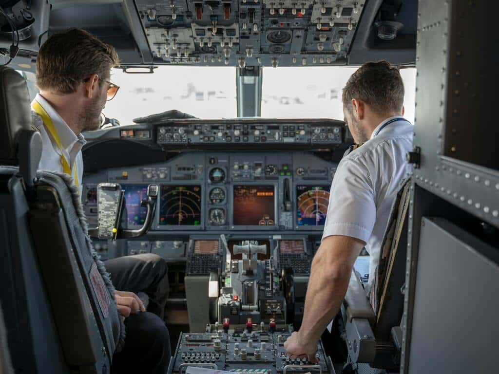 Two pilots on a jet aircraft flightdeck prepare for start up.