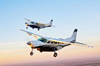 Two Cessna Caravan aircraft fly in formation.