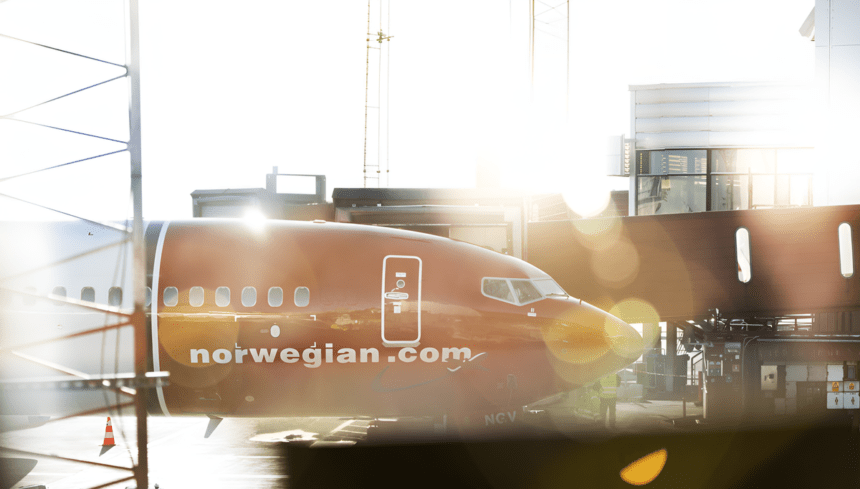 A Norwegian aircraft parked at the terminal.