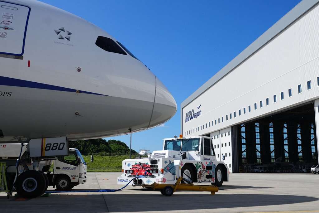 An aircraft parked in front of the MRO Japan hangar.