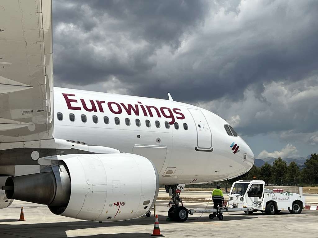 A Eurowings aircraft is hooked to a ground handling tug.