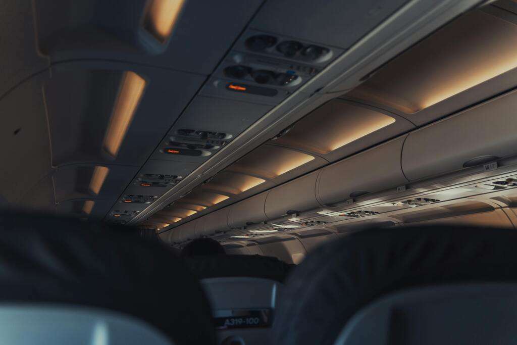 Airline passenger cabin interior with illuminated Seatbelt signs.