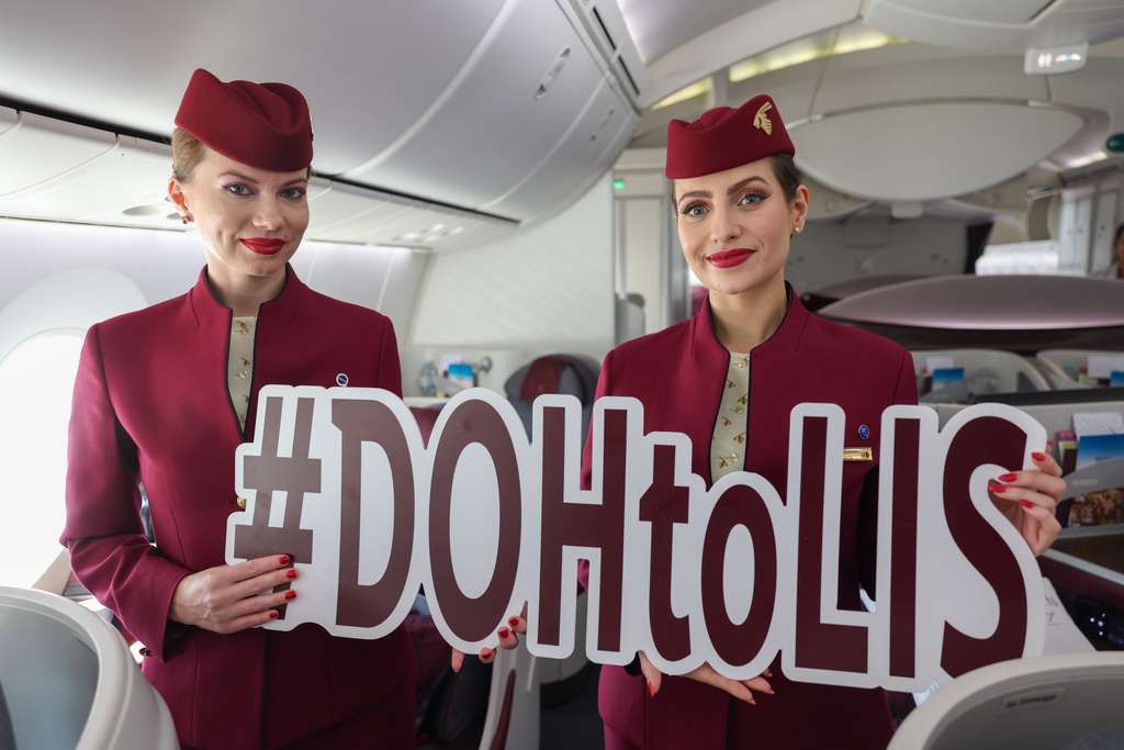 Qatar Airways flight attendants with a Lisbon sign.
