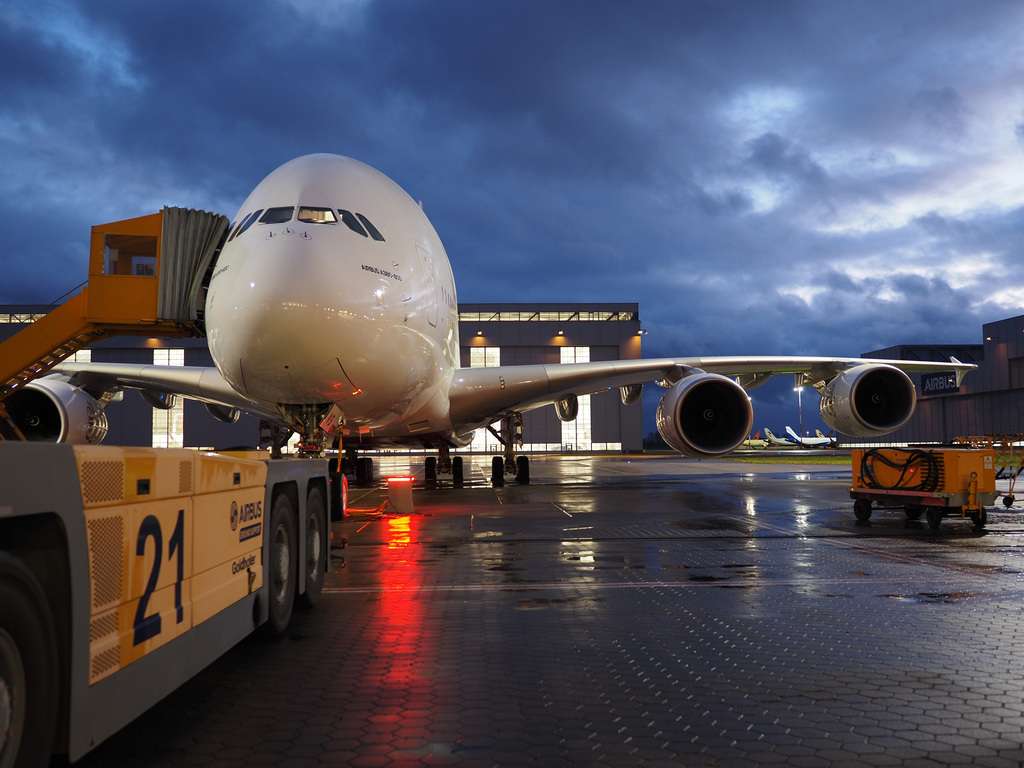 An Airbus A380 under tow at dusk.