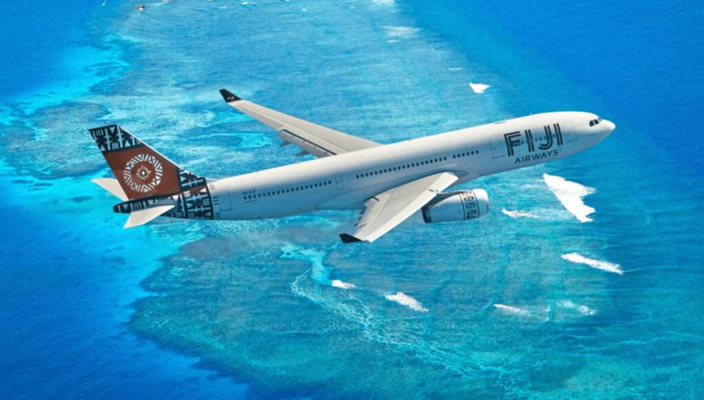 A Fiji Airways aircraft in flight over Fiji atoll.