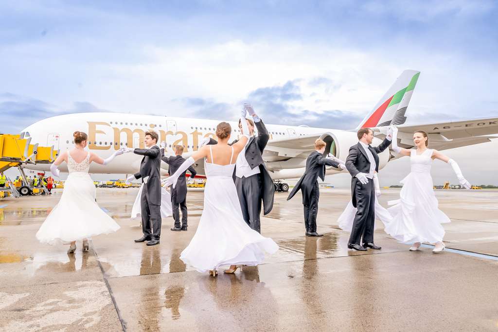 Dancers perform a Viennese dance performance in front of an Emirates aircraft in Vienna, Austria.