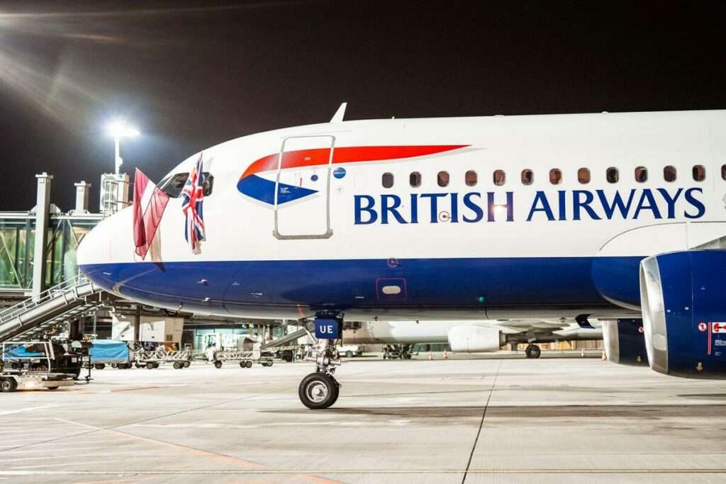 A British Airways aircraft parked at Riga Airport at night.